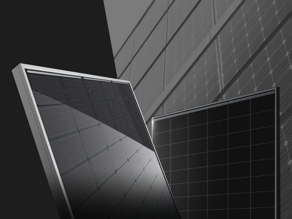 Close-up of two solar panels with a grid pattern, set against a background of more solar panels on a wall.